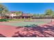 Exterior view of a tennis court with the community recreation center in the background on a sunny day with blue skies at 4617 W Cottontail Rd, Phoenix, AZ 85086
