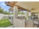 Open backyard with built in grill and manicured outdoor dining and additional grass and patio space at 4618 E Valley View Dr, Phoenix, AZ 85044
