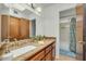 Bathroom with granite countertops, double sinks, and wood cabinets at 4618 E Valley View Dr, Phoenix, AZ 85044