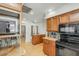 Well-lit kitchen features wood cabinets, granite countertops, a black stove top, and an island at 4618 E Valley View Dr, Phoenix, AZ 85044