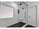 Sleek bathroom with a glass-enclosed shower, black hardware, and contrasting tiles at 4633 E Desert Cactus St, Phoenix, AZ 85032