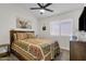 This carpeted bedroom has a patterned bedspread, ceiling fan, and a window at 4633 E Desert Cactus St, Phoenix, AZ 85032