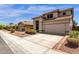Beige home featuring a tile roof, landscaped front yard, and a two-car garage at 4633 E Desert Cactus St, Phoenix, AZ 85032