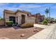 Inviting beige home featuring a tile roof, landscaped front yard, and a two-car garage at 4633 E Desert Cactus St, Phoenix, AZ 85032