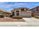 Inviting beige home featuring a tile roof, landscaped front yard, and a two-car garage at 4633 E Desert Cactus St, Phoenix, AZ 85032
