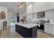Modern kitchen with an island, white cabinets, and stainless steel appliances at 4633 E Desert Cactus St, Phoenix, AZ 85032