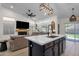 Open-concept living room with a modern fireplace, sleek island, and bright natural light at 4633 E Desert Cactus St, Phoenix, AZ 85032