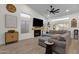 Cozy living room with a fireplace, large sectional sofa, and a mounted television at 4633 E Desert Cactus St, Phoenix, AZ 85032