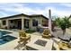 An outdoor entertaining space featuring a stone fire pit with comfortable seating, an outdoor kitchen and BBQ, and a sparkling pool at 5951 N 190Th Dr, Litchfield Park, AZ 85340