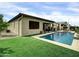Beautiful backyard with a large pool, outdoor kitchen, and well-maintained lawn at 5951 N 190Th Dr, Litchfield Park, AZ 85340