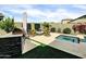 Outdoor kitchen and BBQ area with a fire pit in a beautifully landscaped yard at 5951 N 190Th Dr, Litchfield Park, AZ 85340