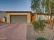 Charming single-Gathering home with a neutral exterior, lush landscaping, and a brick-paved driveway at 5951 N 190Th Dr, Litchfield Park, AZ 85340