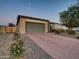 Charming single-Gathering home with a neutral exterior, lush landscaping, and a brick-paved driveway at 5951 N 190Th Dr, Litchfield Park, AZ 85340