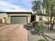 Charming single story home with a manicured front yard and brick paver driveway leading to a gray two car garage at 5951 N 190Th Dr, Litchfield Park, AZ 85340