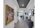 Bright and airy hallway with elegant artwork, dark accent wall, and a glimpse of the living space beyond at 5951 N 190Th Dr, Litchfield Park, AZ 85340