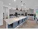 Spacious kitchen with gray cabinets, a large center island with seating, and modern pendant lighting at 5951 N 190Th Dr, Litchfield Park, AZ 85340