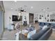 Spacious living room with a modern ceiling fan, sleek furniture, and hardwood floors that connects to the kitchen at 5951 N 190Th Dr, Litchfield Park, AZ 85340
