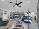 Open concept living room with sleek furniture, hardwood floors, and a modern ceiling fan that leads to the kitchen at 5951 N 190Th Dr, Litchfield Park, AZ 85340