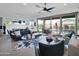 Bright living room with a ceiling fan, hardwood floors, and sliding glass doors to the outdoor pool and patio area at 5951 N 190Th Dr, Litchfield Park, AZ 85340