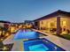 Backyard with sparkling pool and spa, lush landscaping, and covered patio perfect for outdoor living at 5951 N 190Th Dr, Litchfield Park, AZ 85340