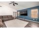 Spacious living room with a large tv, brown leather couch, and modern flooring at 632 W Natal Cir, Mesa, AZ 85210