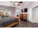 This is a comfortable main bedroom with wood floors, a fan, dressers, and an ensuite bathroom at 632 W Natal Cir, Mesa, AZ 85210