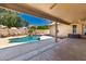 A covered patio overlooks the pool and waterfall feature in the backyard at 632 W Natal Cir, Mesa, AZ 85210