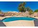 Sparkling pool surrounded by a concrete deck and mature trees providing shade in the backyard at 632 W Natal Cir, Mesa, AZ 85210
