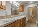 Bathroom featuring tile floors, double sinks, tile countertop, and a mirror with vanity lights at 7240 W Grovers Ave, Glendale, AZ 85308