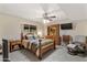 Bedroom with carpet floors, window, ceiling fan, TV, and wooden bed frame with matching dresser at 7240 W Grovers Ave, Glendale, AZ 85308