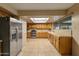 Spacious kitchen with stainless steel appliances, tile countertops, and skylight offering ample natural light at 7240 W Grovers Ave, Glendale, AZ 85308