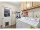 Laundry room featuring a washer and dryer, shelving, and a door with a window and dog door at 7240 W Grovers Ave, Glendale, AZ 85308