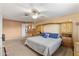 Spacious bedroom with carpet floors, fan, and built-in wood storage surrounding the head of the bed at 7240 W Grovers Ave, Glendale, AZ 85308