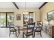 Elegant dining room featuring a glass-top table, comfortable chairs, and natural light from sliding glass doors at 7552 N San Manuel Rd, Scottsdale, AZ 85258