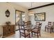 Elegant dining room with glass table, stylish chairs, and sliding doors to the outdoor area at 7552 N San Manuel Rd, Scottsdale, AZ 85258
