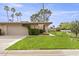 Charming single-story home featuring a lush front lawn and mature landscaping, including palm trees at 7552 N San Manuel Rd, Scottsdale, AZ 85258
