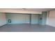 Spacious garage with epoxy floor, teal walls, a door, and plenty of room for storage and vehicles at 7552 N San Manuel Rd, Scottsdale, AZ 85258