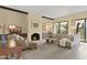 Cozy living room with a fireplace, comfortable seating, neutral tones, and access to the patio at 7552 N San Manuel Rd, Scottsdale, AZ 85258