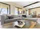 Bright living area featuring a plush sectional sofa, large windows, and an open flow to the dining space at 7552 N San Manuel Rd, Scottsdale, AZ 85258