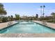 Community pool with blue water, surrounding lounge area, and mature trees providing shade for relaxation at 7552 N San Manuel Rd, Scottsdale, AZ 85258