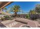 This backyard has a palm tree and rock landscaping, as well as a fire pit and wooden bench at 829 S Roanoke St, Gilbert, AZ 85296