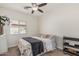 Well lit bedroom with neutral colors, ceiling fan, and large window at 829 S Roanoke St, Gilbert, AZ 85296