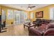 Cozy living room with a ceiling fan, hardwood floors, plantation shutters, and comfortable leather seating at 829 S Roanoke St, Gilbert, AZ 85296