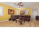 Inviting living room with wood floors, ceiling fan, yellow walls, and a view into the kitchen at 829 S Roanoke St, Gilbert, AZ 85296