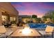 Entertain guests around the fire pit with views of the pool and covered patio at 8733 E Jacaranda St, Mesa, AZ 85207