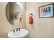 This bathroom features a pedestal sink, a round mirror, and framed artwork at 8733 E Jacaranda St, Mesa, AZ 85207