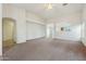 Spacious living room showcasing neutral carpet, and an arched entrance to other rooms at 89 S 151St Ave, Goodyear, AZ 85338