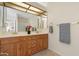 Bathroom with a double sink, vanity, large mirror, and a decorative flower arrangement at 9349 E Navajo Pl, Sun Lakes, AZ 85248