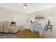 Bright bedroom with a ceiling fan, a patterned chair, and decoratively pillowed bed at 9349 E Navajo Pl, Sun Lakes, AZ 85248