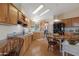 Well-lit kitchen features hardwood floors, ample cabinet space, modern appliances and an adjacent dining area at 9349 E Navajo Pl, Sun Lakes, AZ 85248